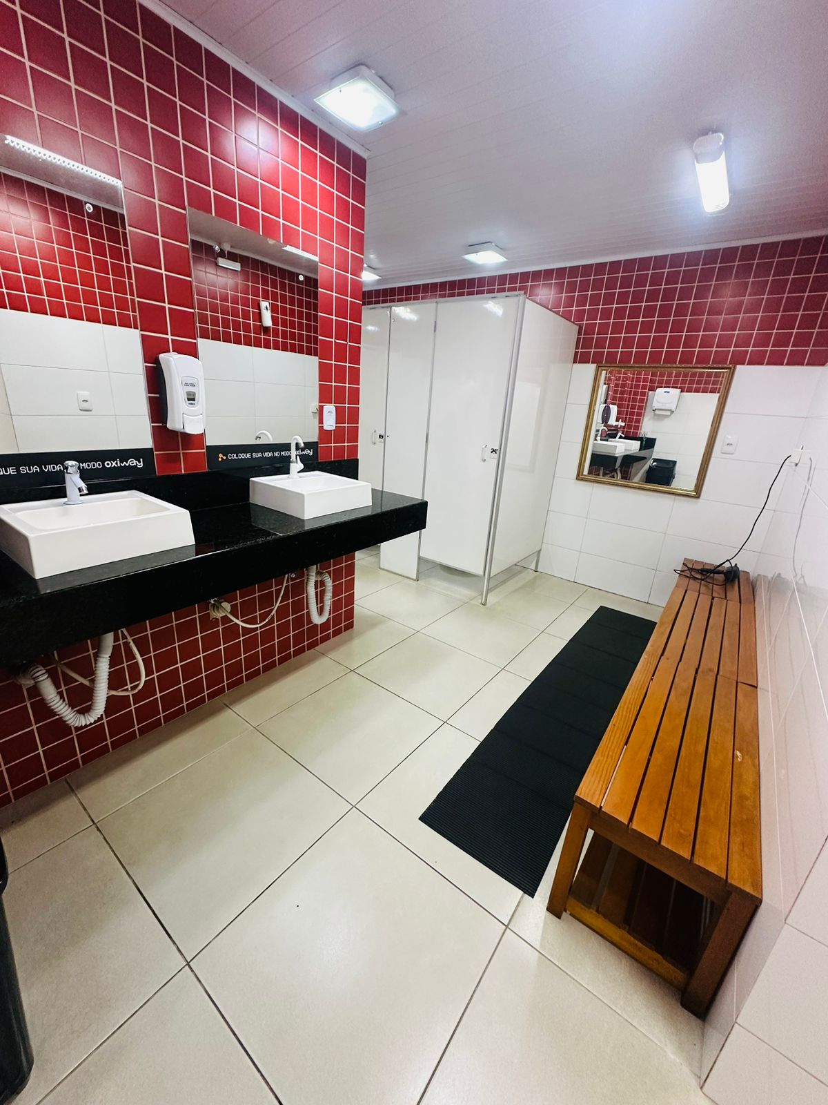 Vestiário com duchas e bancos no Studio Oxigênio Chapecó